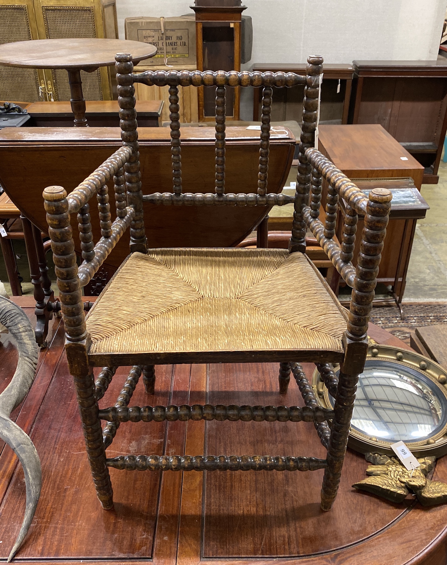 A late Victorian beech bobbin turned rush seat elbow chair, height 90cm.